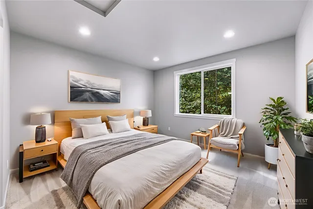 a bedroom with a large bed and a potted plant