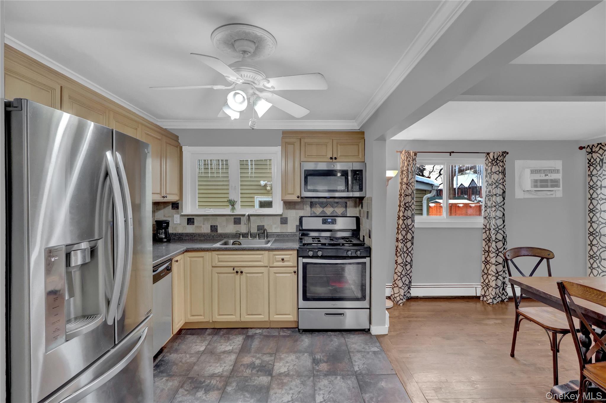 199 August Road North Babylon, NY 11703 - Photo 12 of 32 Kitchen featuring stainless steel appliances, tasteful backsplash, ceiling fan, dark countertops, and crown molding