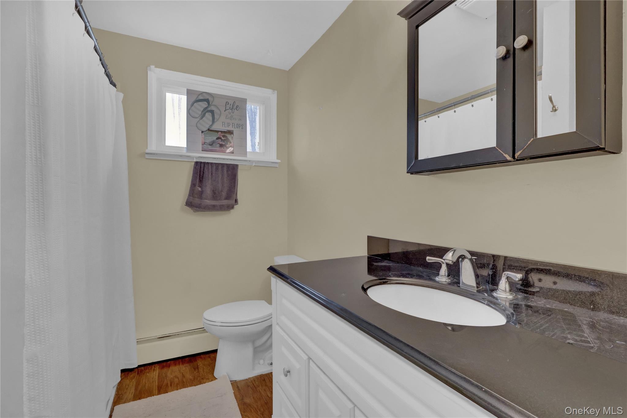 199 August Road North Babylon, NY 11703 - Photo 24 of 32 2nd floor Bathroom with a shower with shower curtain, a baseboard heating unit, light wood-type flooring, and vanity