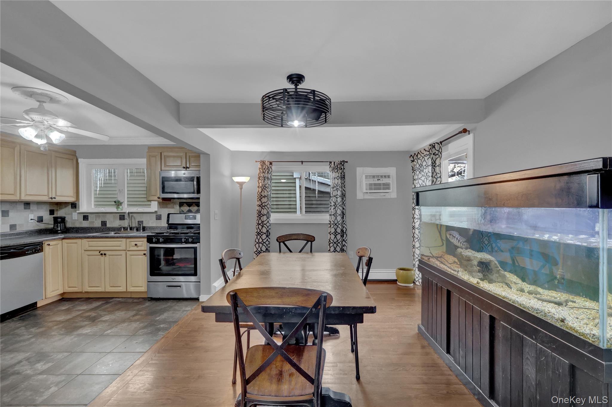 199 August Road North Babylon, NY 11703 - Photo 8 of 32 Kitchen with backsplash, appliances with stainless steel finishes, dark wood finished floors, a wall mounted air conditioner, and a ceiling fan