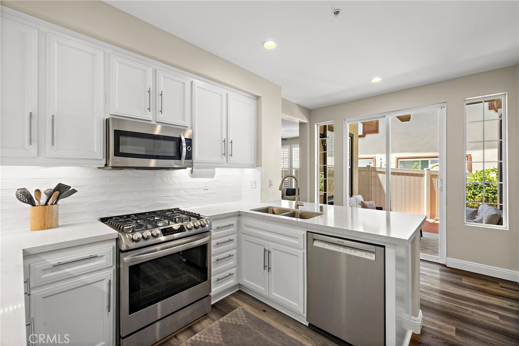 71 Sklar Street Ladera Ranch, CA 92694 - Photo 12 of 55 a kitchen with stainless steel appliances granite countertop a stove a sink and a microwave