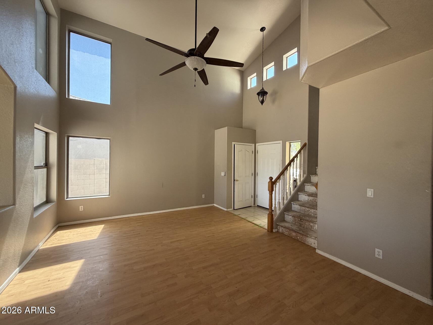 10807 West Monte Vista Road Avondale, AZ 85392 - Photo 14 of 33 a view of an empty room with stairs and a ceiling fan