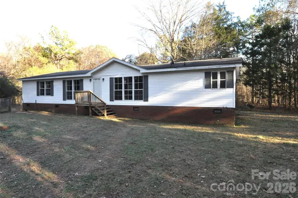 a view of a house with a yard and large tree