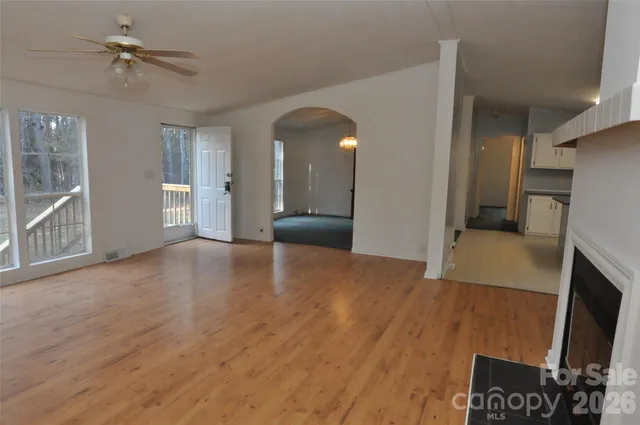 a view of empty room with a fireplace and wooden floor