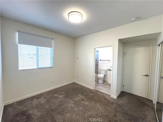 an empty room with a cabinet and a window