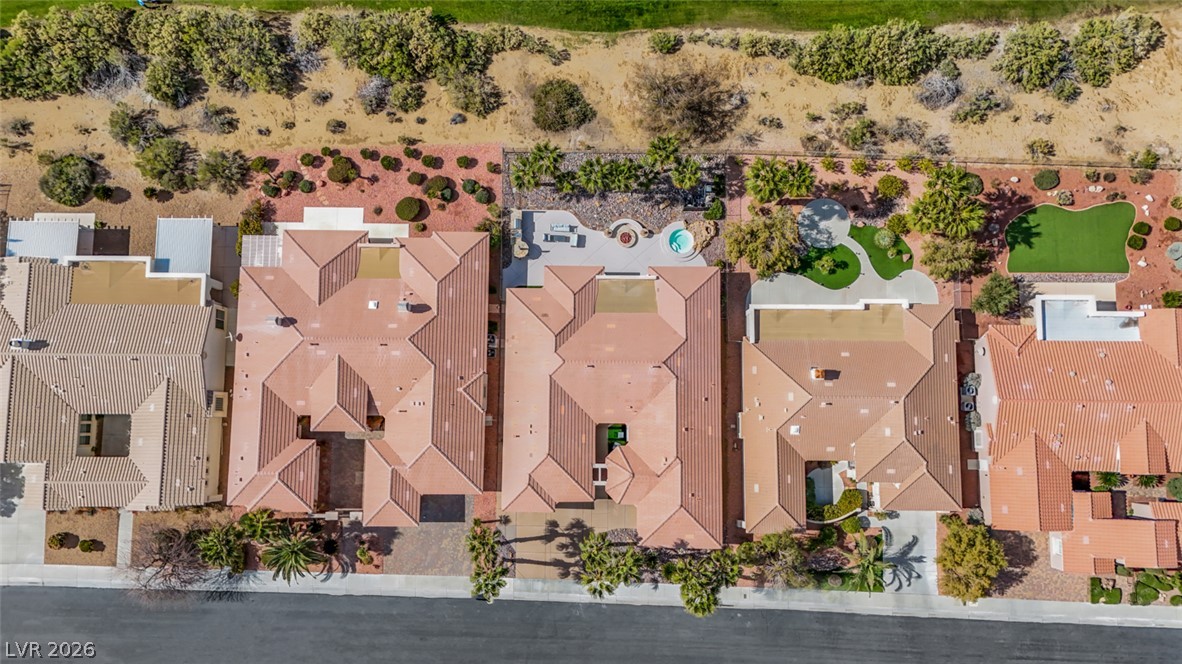 5015 Rivedro Street Las Vegas, NV 89135 - Photo 80 of 91 An aerial perspective reveals a private yard featuring a putting green, inviting spa, and fire pit, all bordering open desert landscape.