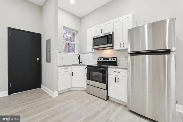 a kitchen with white cabinets and white appliances