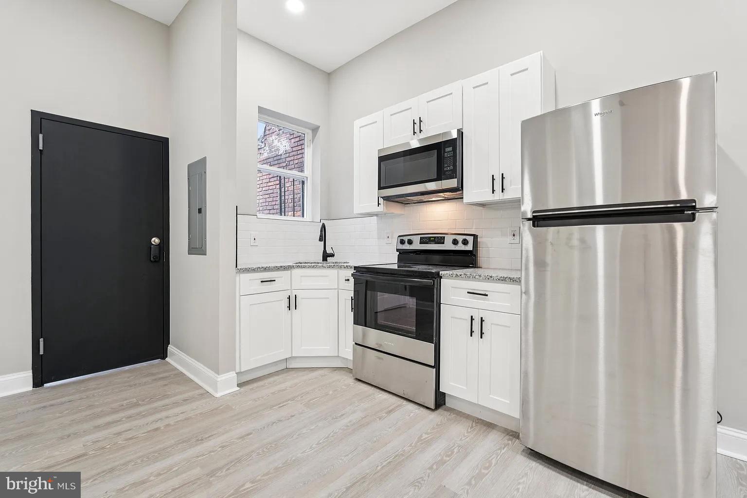 916 North Arlington Avenue, Unit 3 Baltimore, MD 21217 - Photo 2 of 7 a kitchen with white cabinets and white appliances