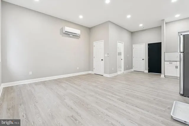 a view of an empty room with wooden floor