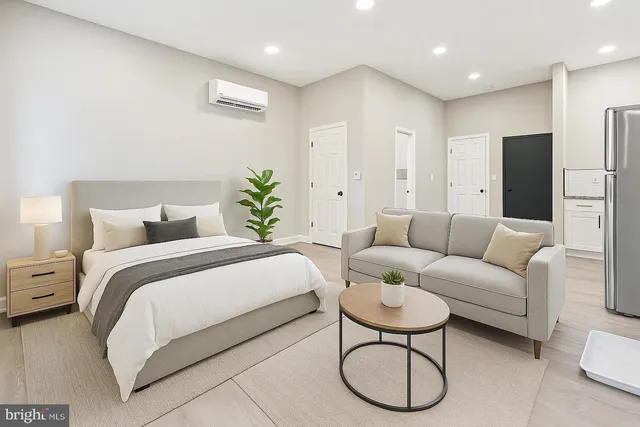 a spacious bedroom with a bed a couch and a potted plant