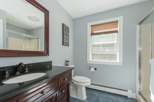 39 R Kimball Road Amesbury, MA 01913 - Photo 15 of 28 a bathroom with a granite countertop sink toilet a mirror and a window