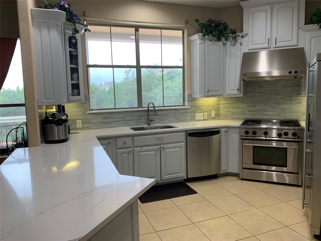 4325 Lago Viento Austin, TX 78734 - Photo 13 of 39 a kitchen with a sink stove and cabinets