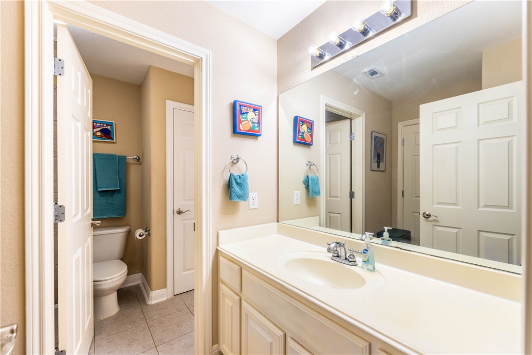 4325 Lago Viento Austin, TX 78734 - Photo 27 of 39 a bathroom with a sink and mirror with toilet