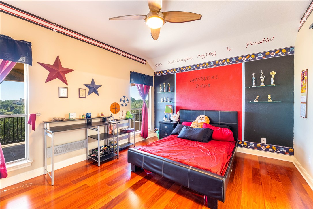 4325 Lago Viento Austin, TX 78734 - Photo 29 of 39 a bedroom with a large bed and a chandelier