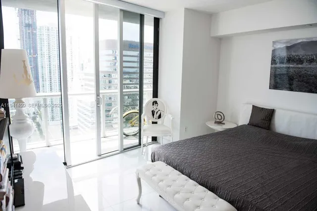 a bedroom with a large bed and a large window with outer view