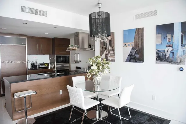 a dining room with furniture and kitchen view