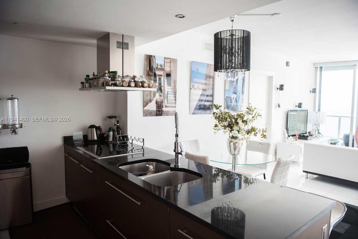 495 Brickell Avenue, Unit 3805 Miami, FL 33131 - Photo 4 of 18 a kitchen with stainless steel appliances a sink a counter space and living room view