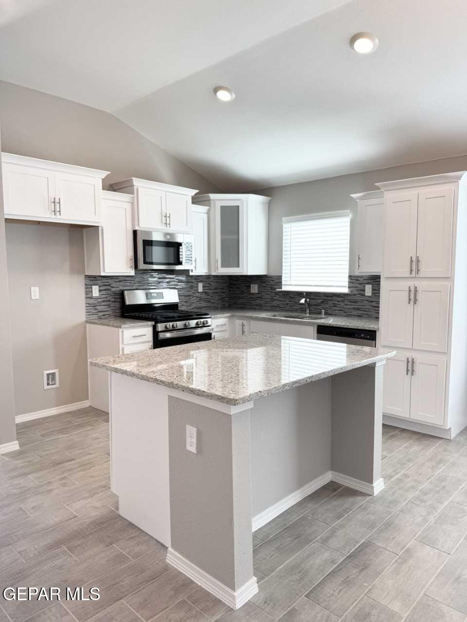 12409 Caddo Lane Clint, TX 79836 - Photo 2 of 13 a kitchen with stainless steel appliances granite countertop a stove top oven a sink a refrigerator and white cabinets