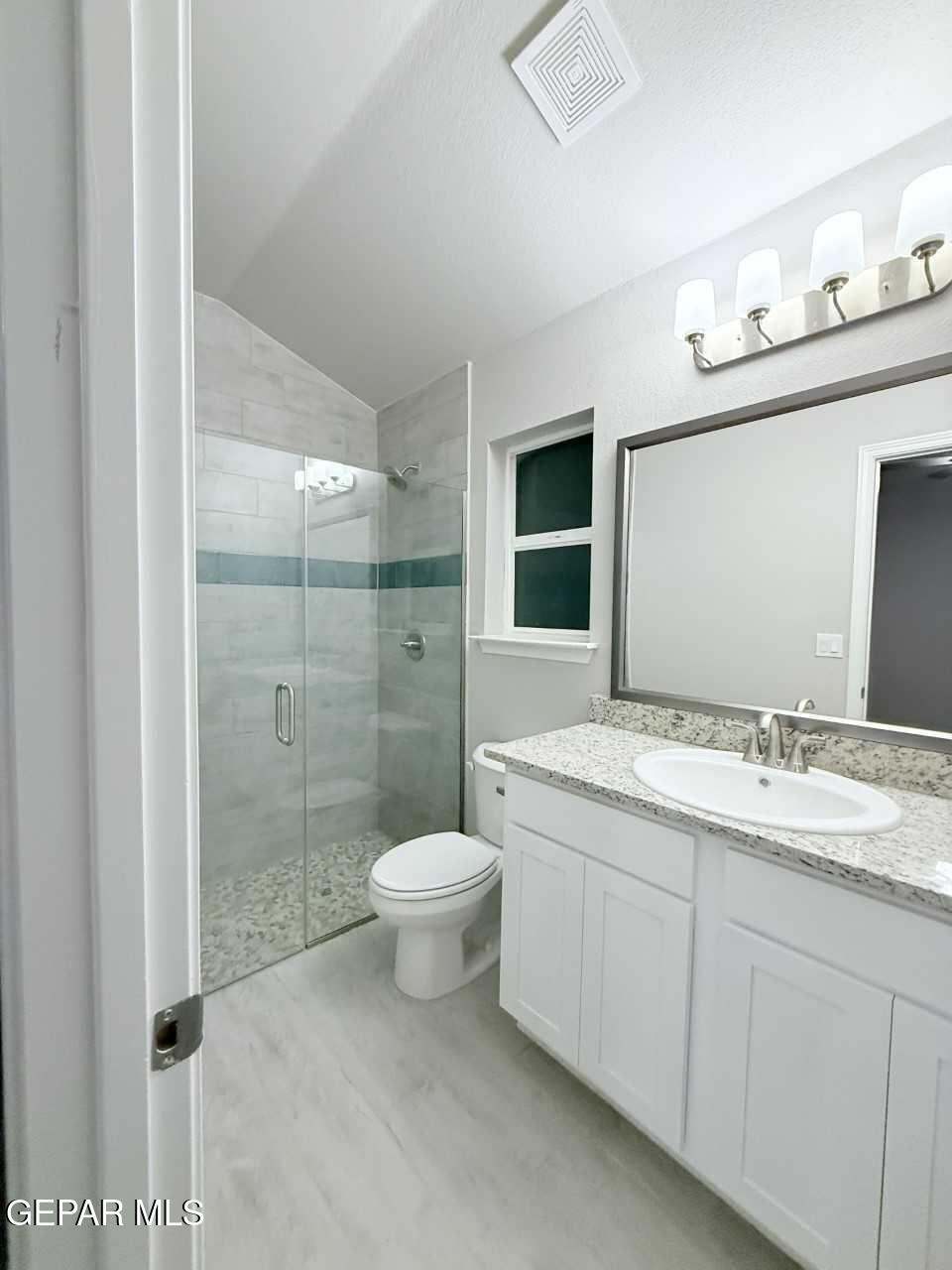 12409 Caddo Lane Clint, TX 79836 - Photo 10 of 13 a bathroom with a granite countertop sink toilet a mirror a vanity and shower