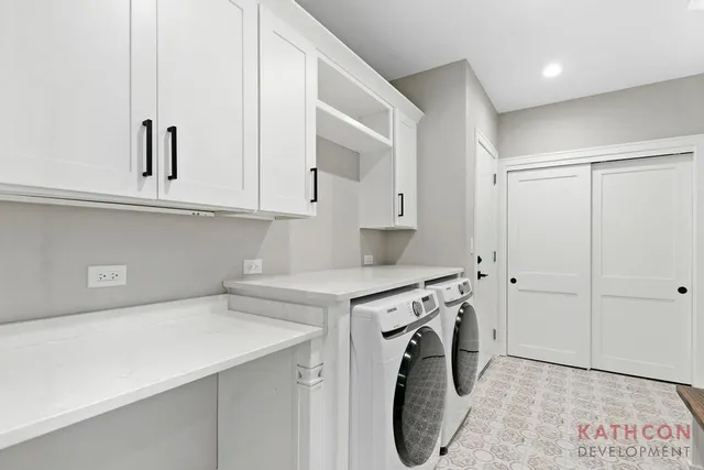 a utility room with cabinets washer and dryer