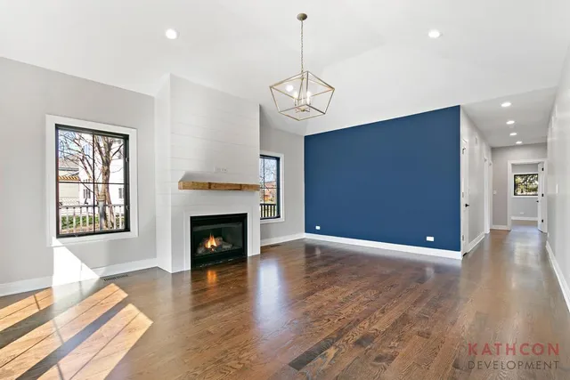 a view of a livingroom with wooden floor and a fireplace
