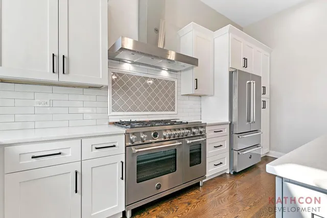 a kitchen with granite countertop white cabinets and stainless steel appliances