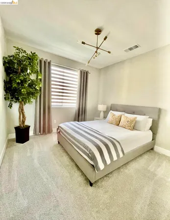 a bedroom with a bed and a potted plant