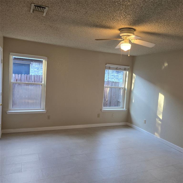 7905 Flowertree Court Fort Worth, TX 76137 - Photo 6 of 17 an empty room with windows and fan