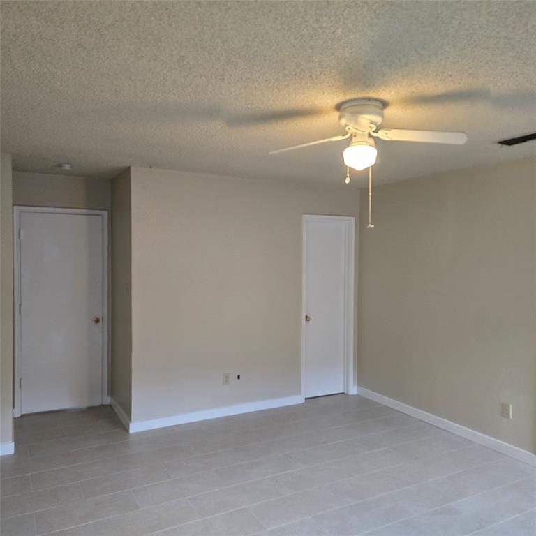 7905 Flowertree Court Fort Worth, TX 76137 - Photo 7 of 17 an empty room with a fan & a ceiling fan
