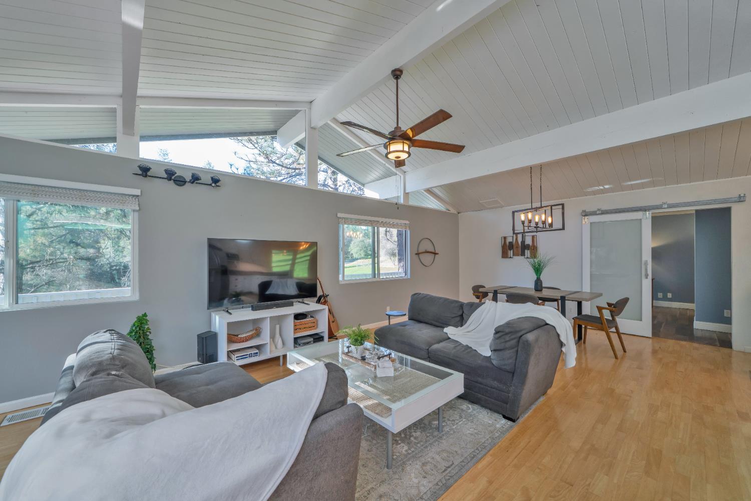 2869 Cascade Trail Cool, CA 95614 - Photo 18 of 80 a living room with furniture a chandelier and a flat screen tv