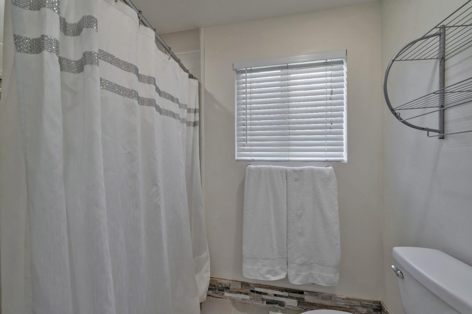 2869 Cascade Trail Cool, CA 95614 - Photo 24 of 80 a bathroom with a shower curtain a sink and a toilet