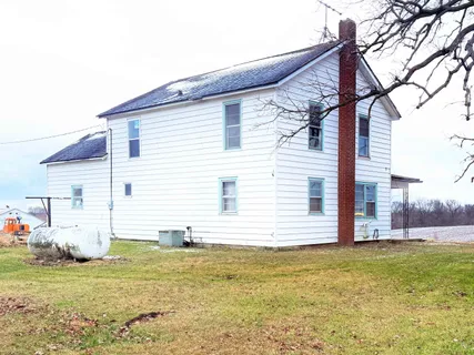 a view of a house with a yard and sitting area