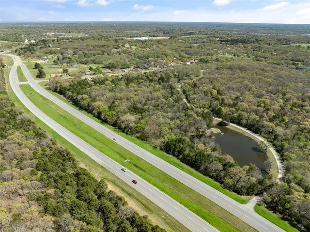 an aerial view of residential houses with outdoor space and trees