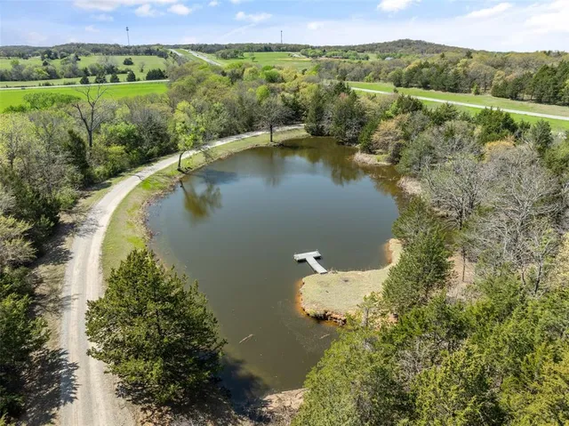 an aerial view of a house with a yard and lake view