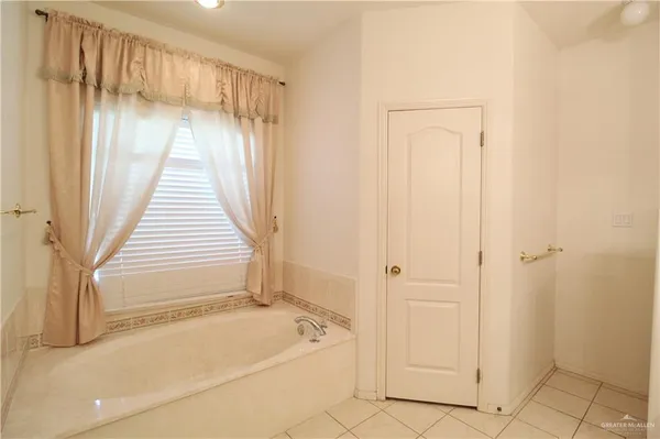 a spacious bathroom with a tub shower and sink