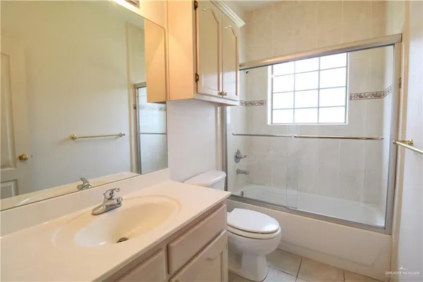 an empty room with a chandelier fan and windows