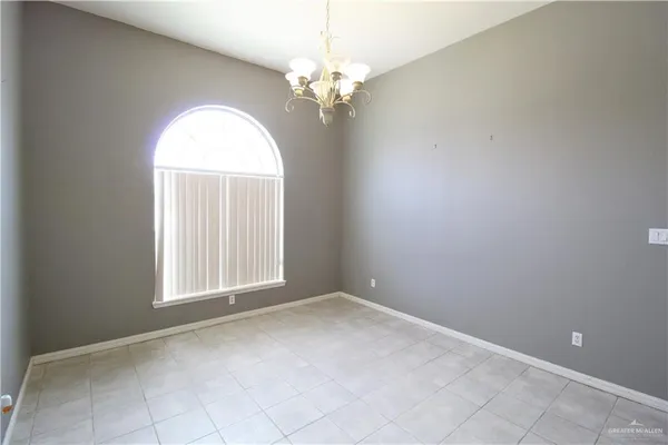 an empty room with windows and chandelier