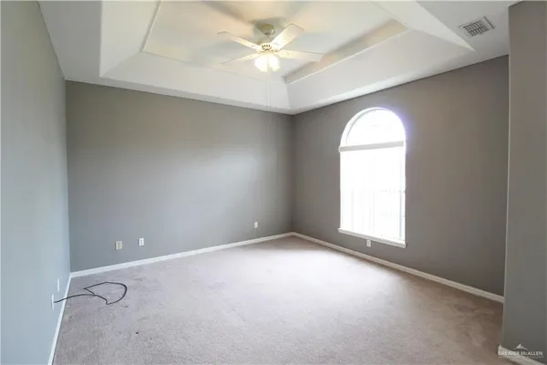 an empty room with a window and a ceiling fan