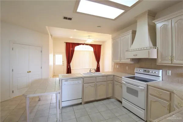 a kitchen with white cabinets and white appliances