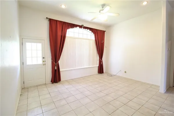 an empty room with windows and fan