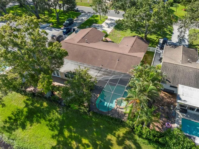 an aerial view of residential house with outdoor space and trees all around