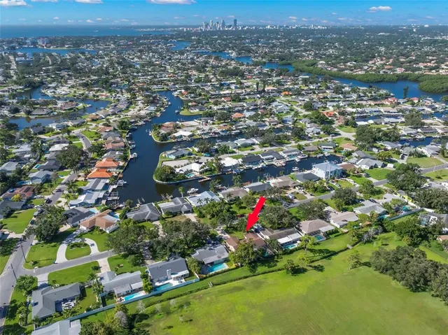 an aerial view of residential houses with outdoor space and trees