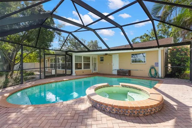 a view of a house with a swimming pool and sitting area