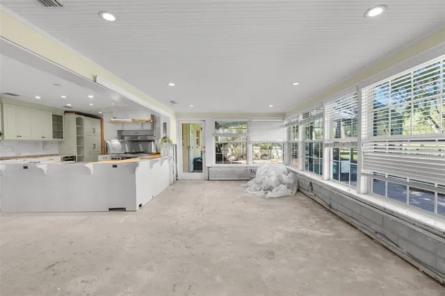 a large white room with a large white bed cabinets and a couch