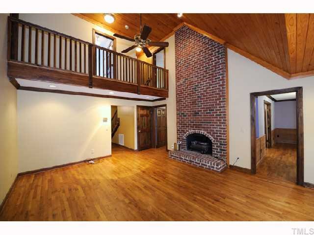 9265 Sauls Road Raleigh, NC 27603 - Photo 8 of 12 a view of empty room with wooden floor and fireplace