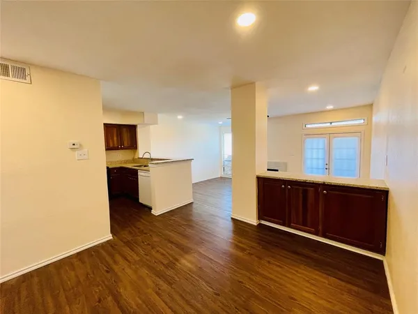 a kitchen with stainless steel appliances granite countertop a sink a stove and a wooden floors
