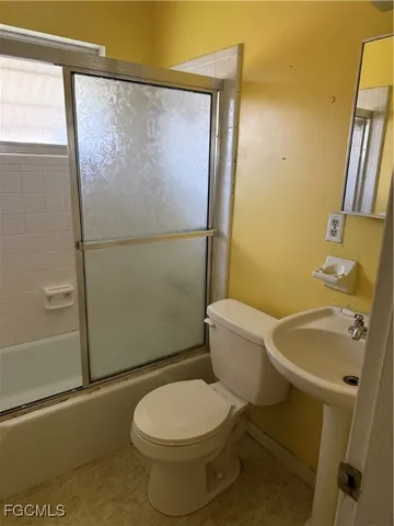 a white toilet sitting next to a bathroom sink