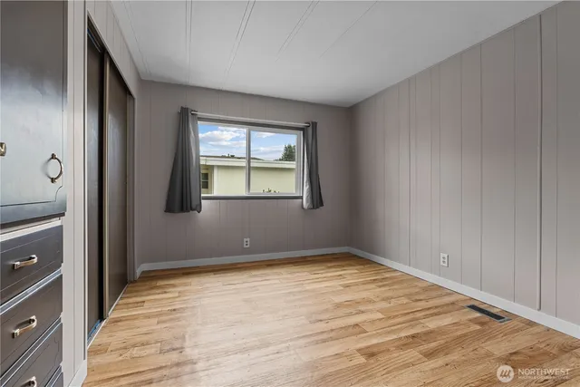 an empty room with windows and closet