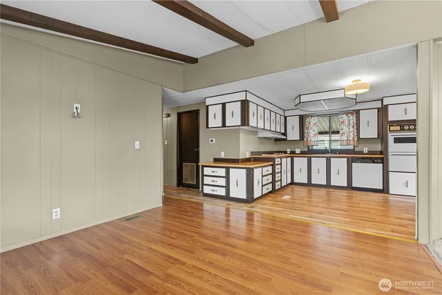 a living room with stainless steel appliances kitchen island granite countertop a kitchen view and a stove
