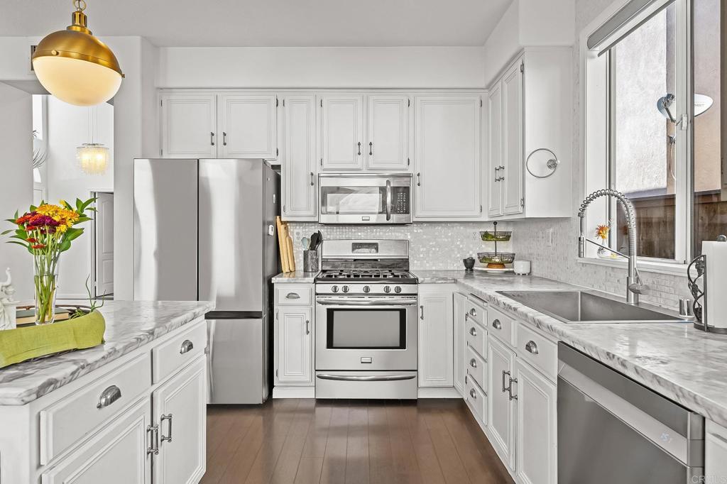 120 Venetia Way Oceanside, CA 92057 - Photo 2 of 32 a kitchen with granite countertop a white stove top oven and refrigerator